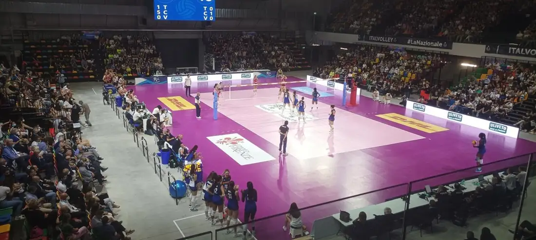 Interno del palasport durante una partita della nazionale femminile di pallavolo, con tribune piene
