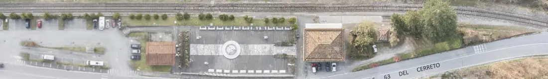 Vista aerea zenitale della stazione, della Piazza dei Parchi e della ferrovia lungo la statale 63