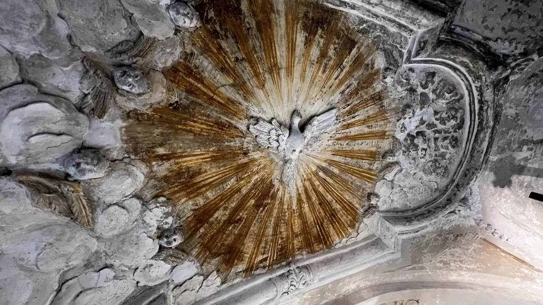 Dopo il restauro: la colomba dello Spirito Santo al centro della raggiera dorata riportata alla luce, tra stucchi e cherubini