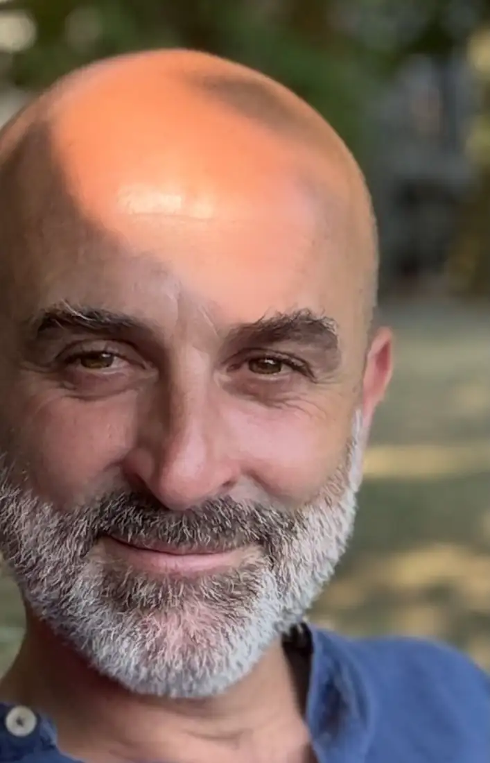 Ritratto dell'architetto Stefano Santini, sorridente, all'aperto