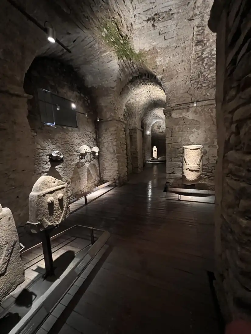 Sala del Museo delle Statue Stele nel Castello del Piagnaro: volte in pietra illuminate e statue stele lungo il percorso